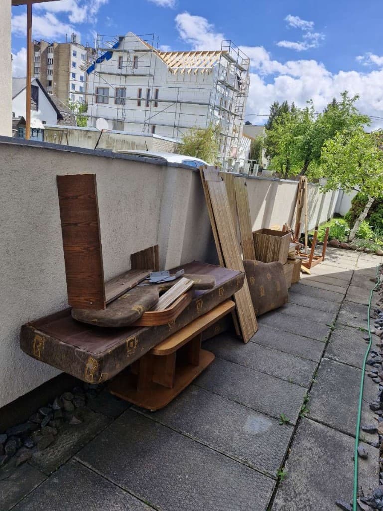 Išardyti seni baldai prie sienos